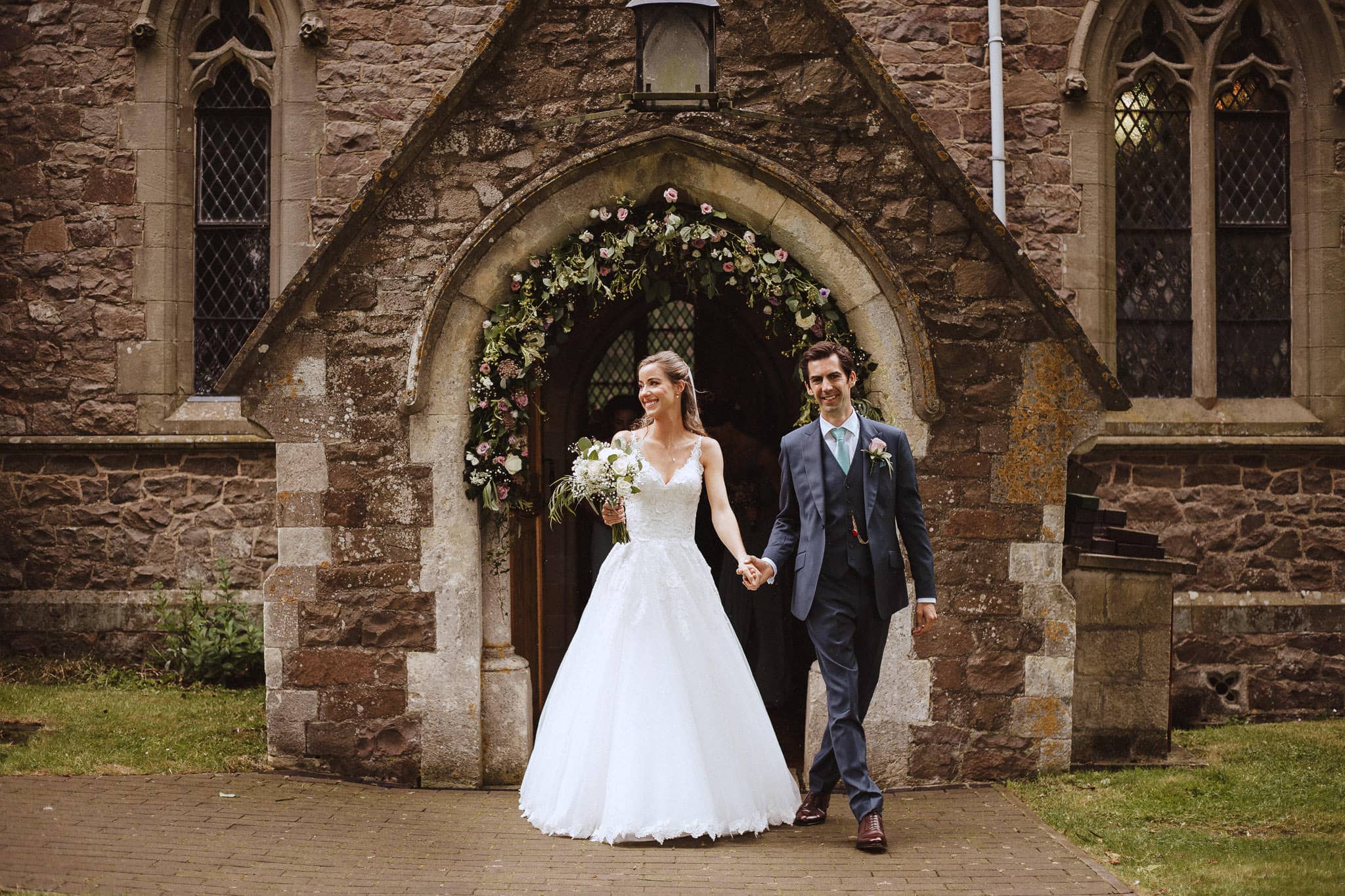 bride and groom exit the church at their Leicestershire wedding
