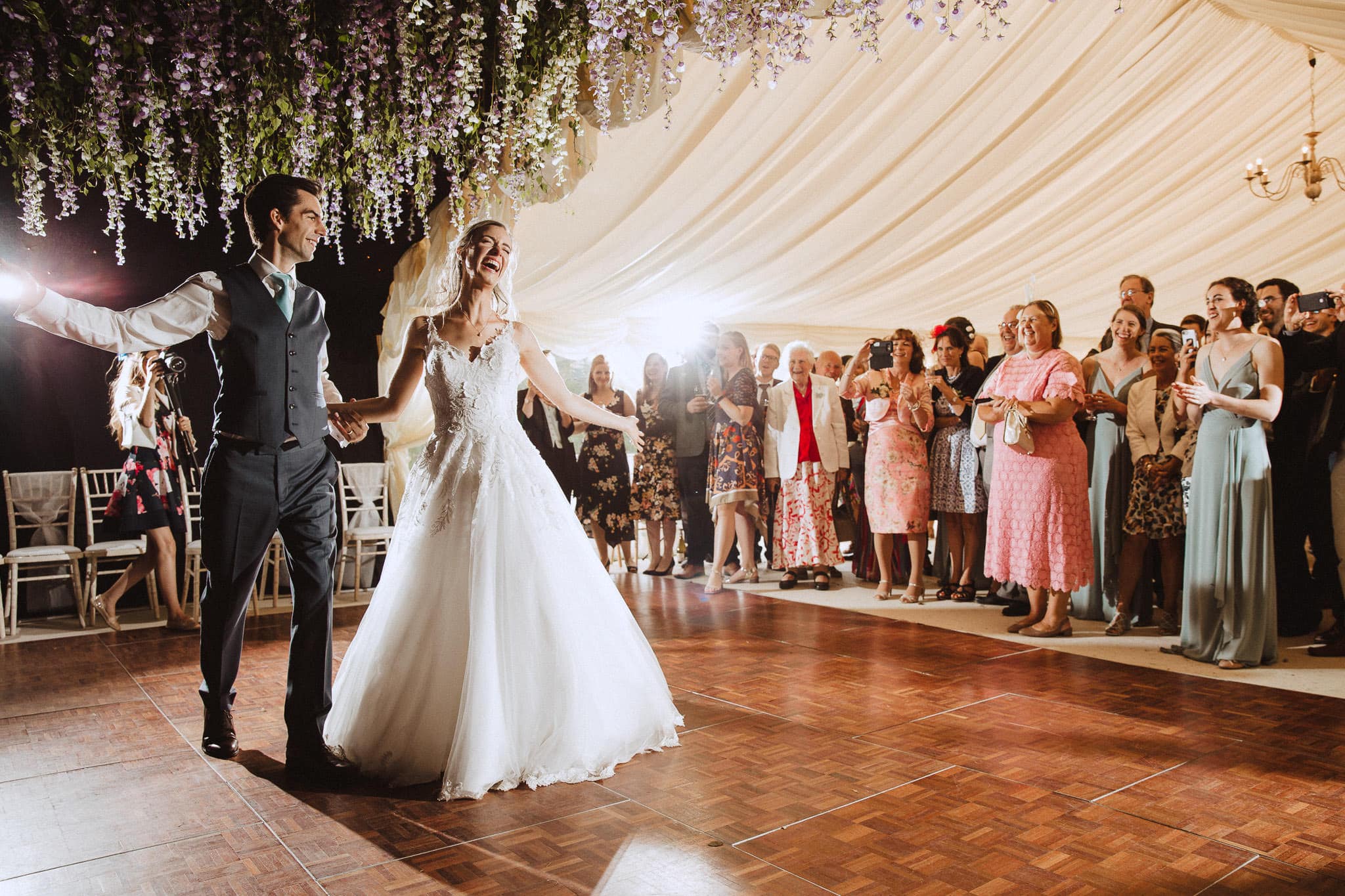 stunning first dance photo with hanging flowers in marquee