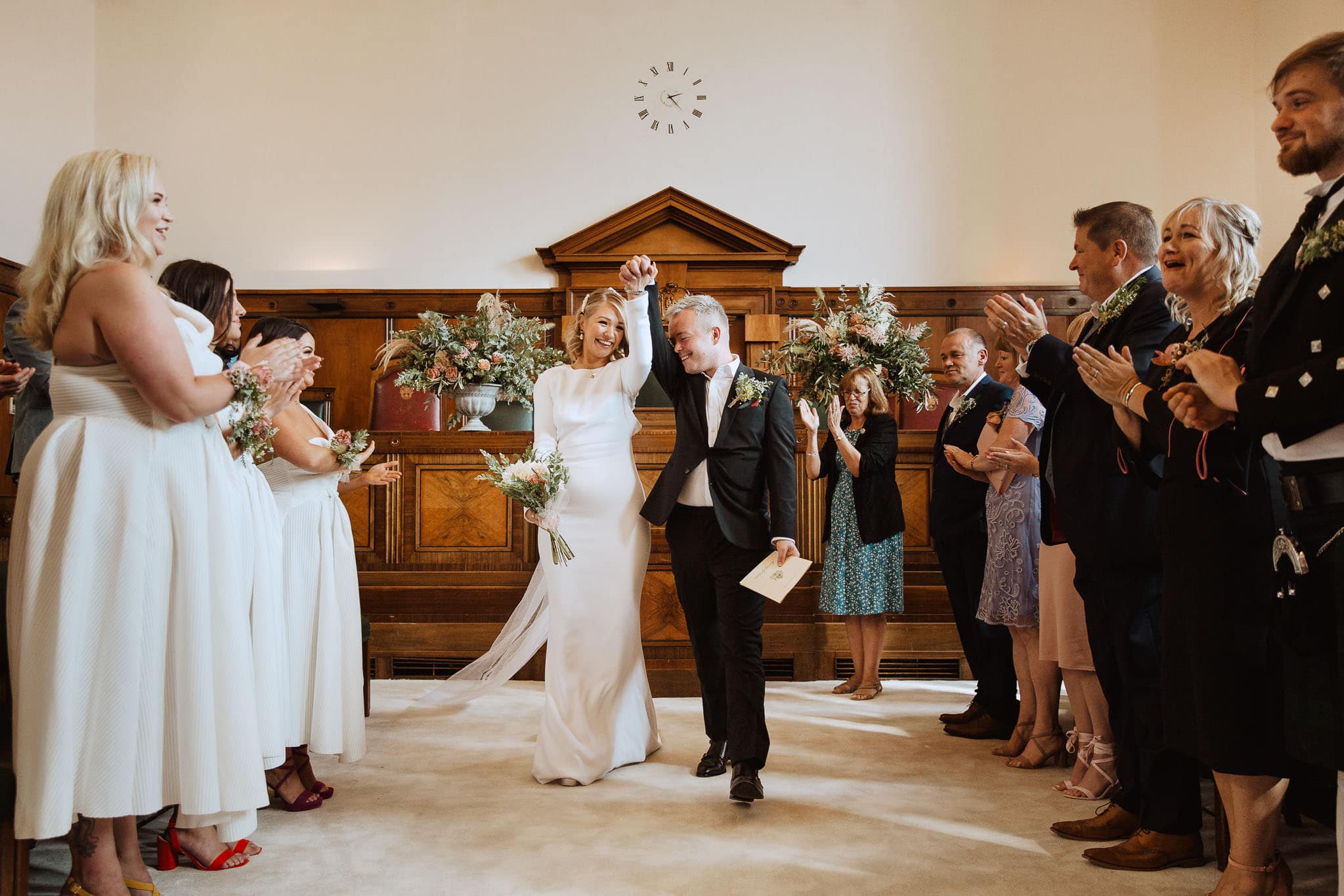 fist pump as bride and groom exit Council Chamber, Town Hall Hotel Wedding, London