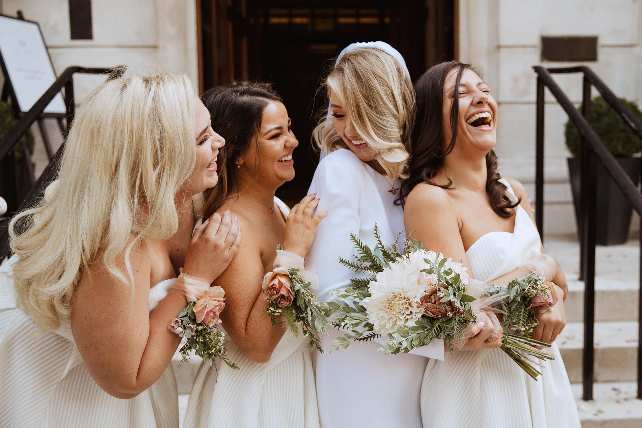 bride in Stella McCartney wedding dress laughing with bridesmaids
