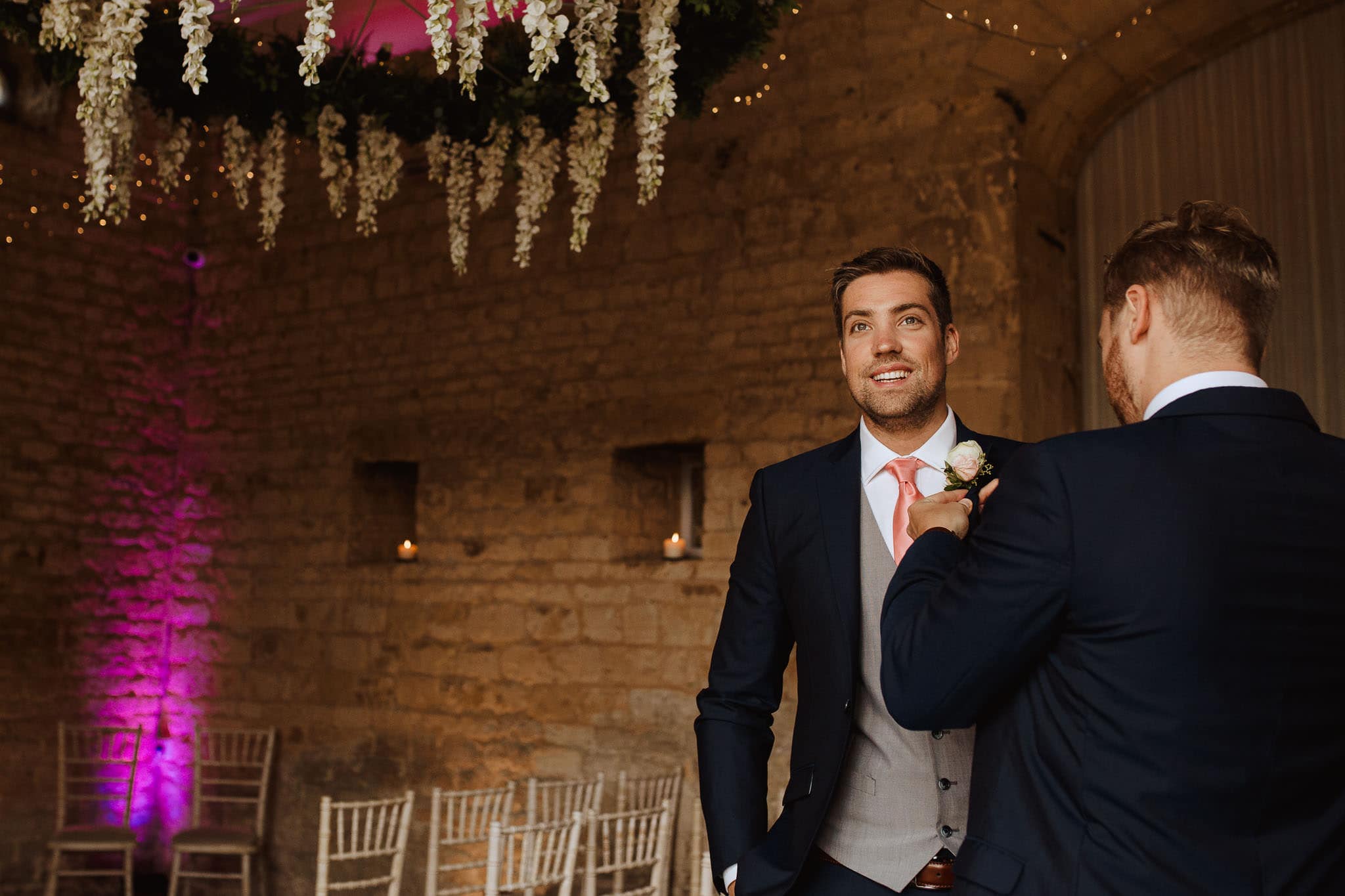 Groom putting on buttonhole in Lapstone Barn