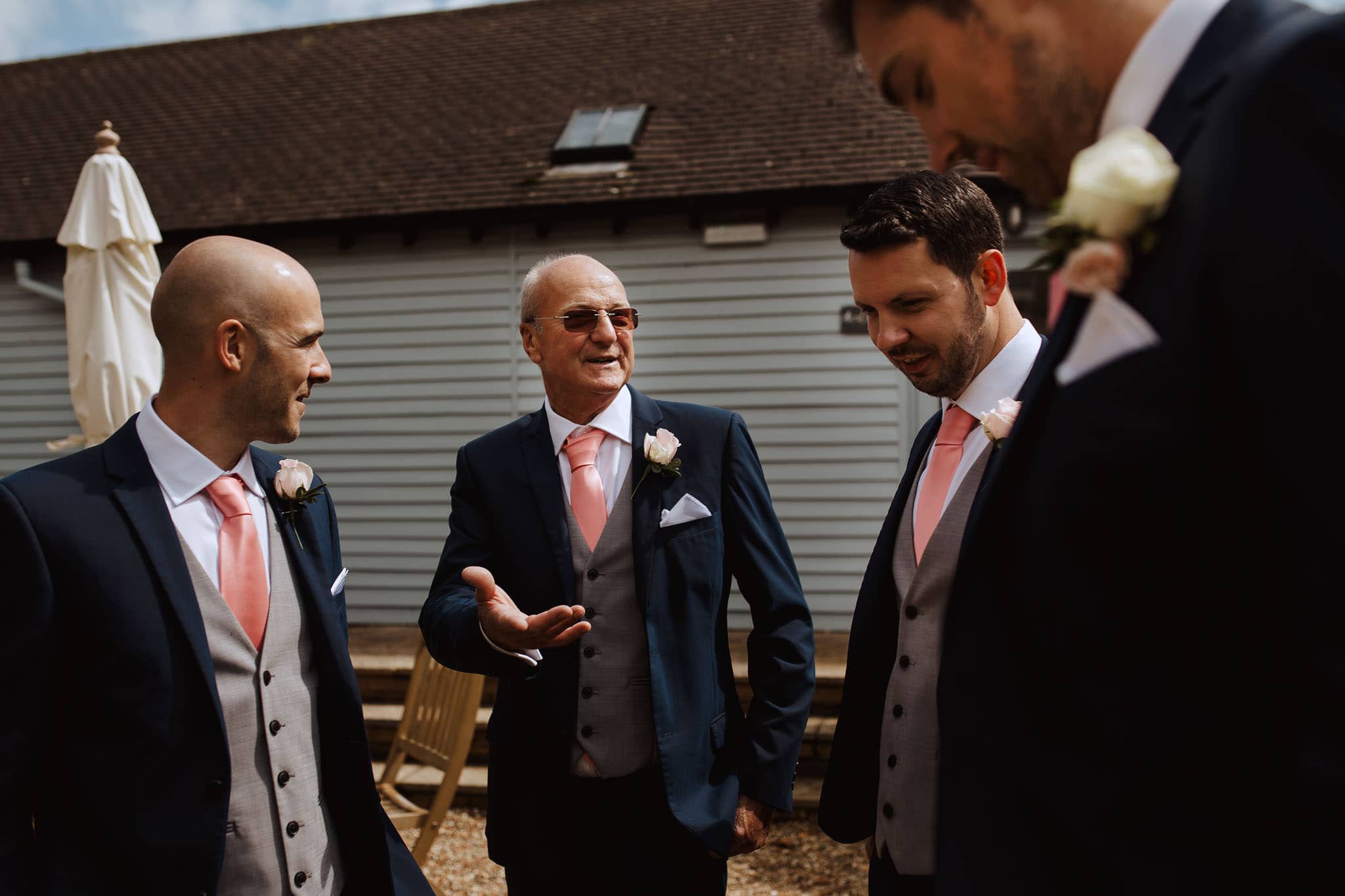 groomsmen chatting in courtyard at Lapstone Barn Wedding venue The Cotswolds