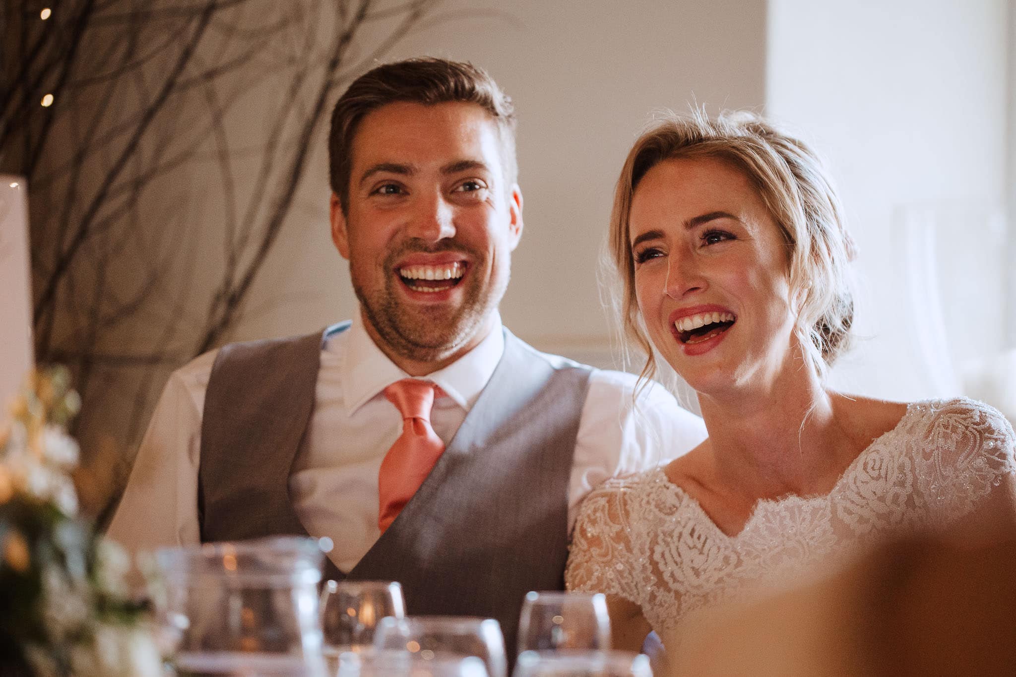 bride and groom laughing at best man's speech at Lapstone Barn