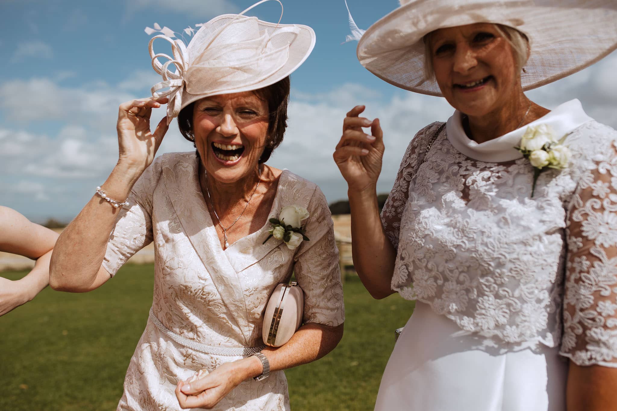 guests laughing on a windy wedding day