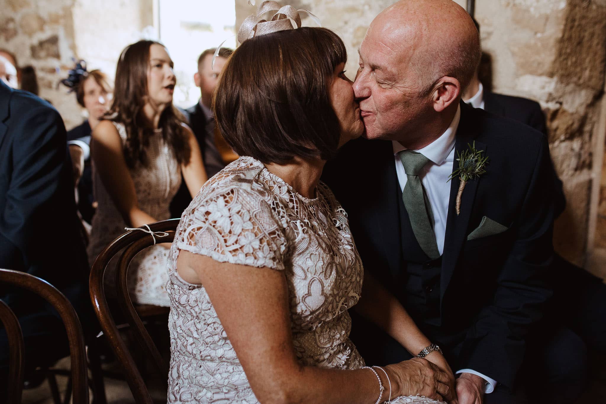 candid shot of parents stealing a kiss at Healey Barn wedding