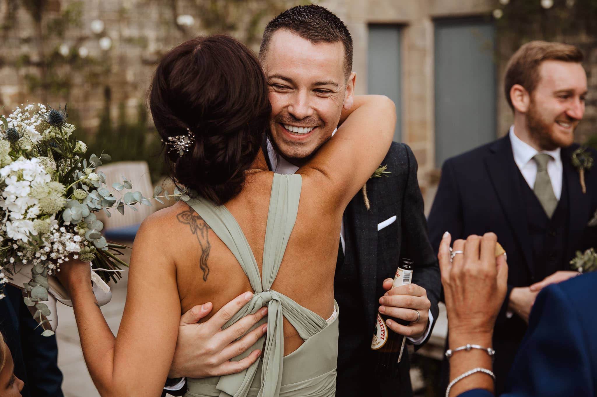 groom and sister hugging after wedding ceremony