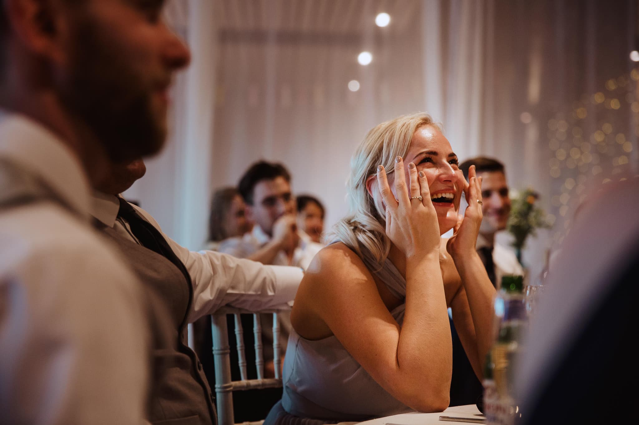 emotional bridesmaid captured wiping tears away
