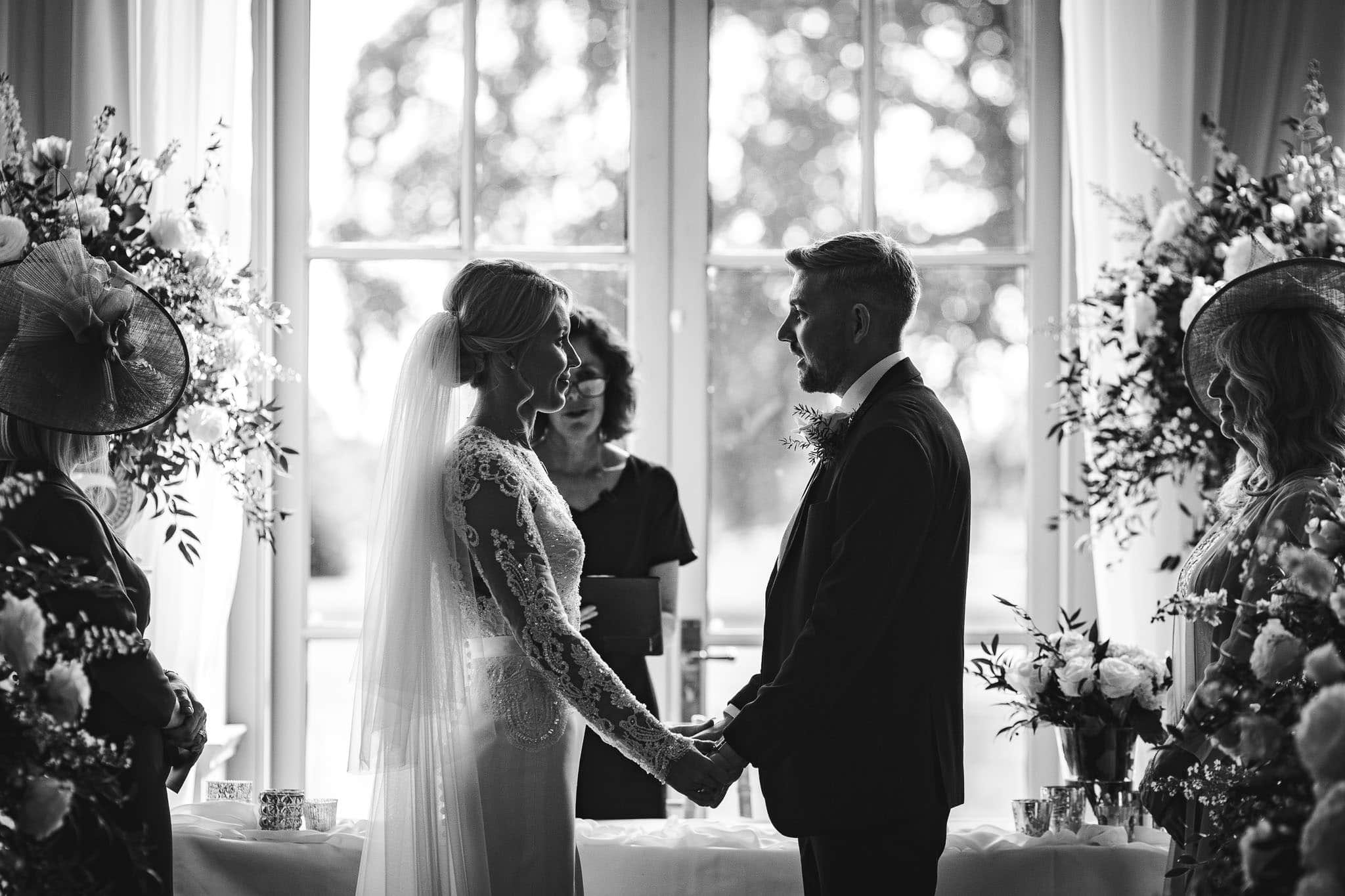 black and white close up of bride and groom exchanging vows at Stubton Hall wedding