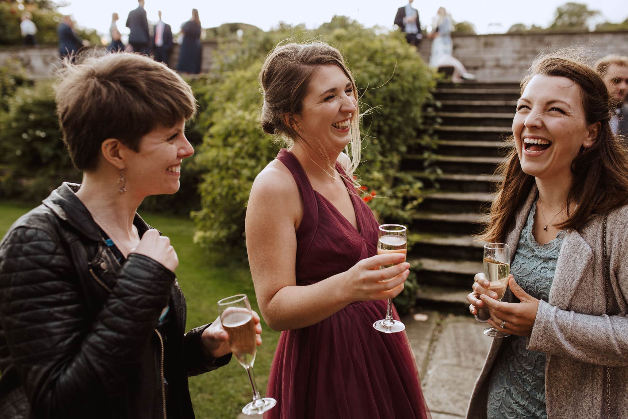 candid photo of guests laughing at Mums laughing together during Tissington Hall wedding drinks reception