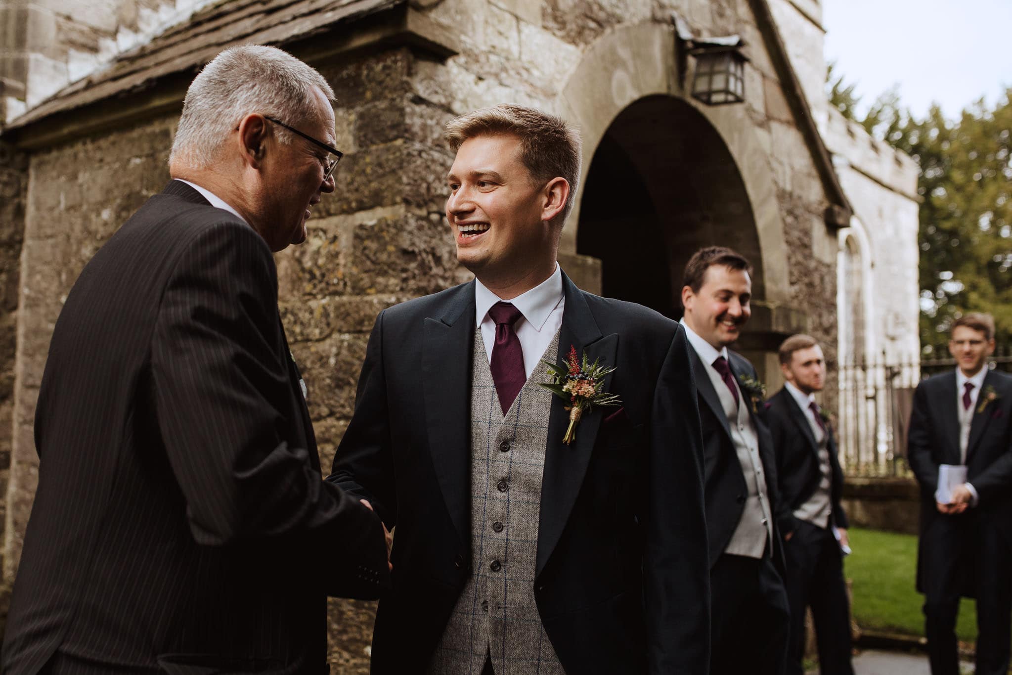 shot of the groom greeting his guests at the church