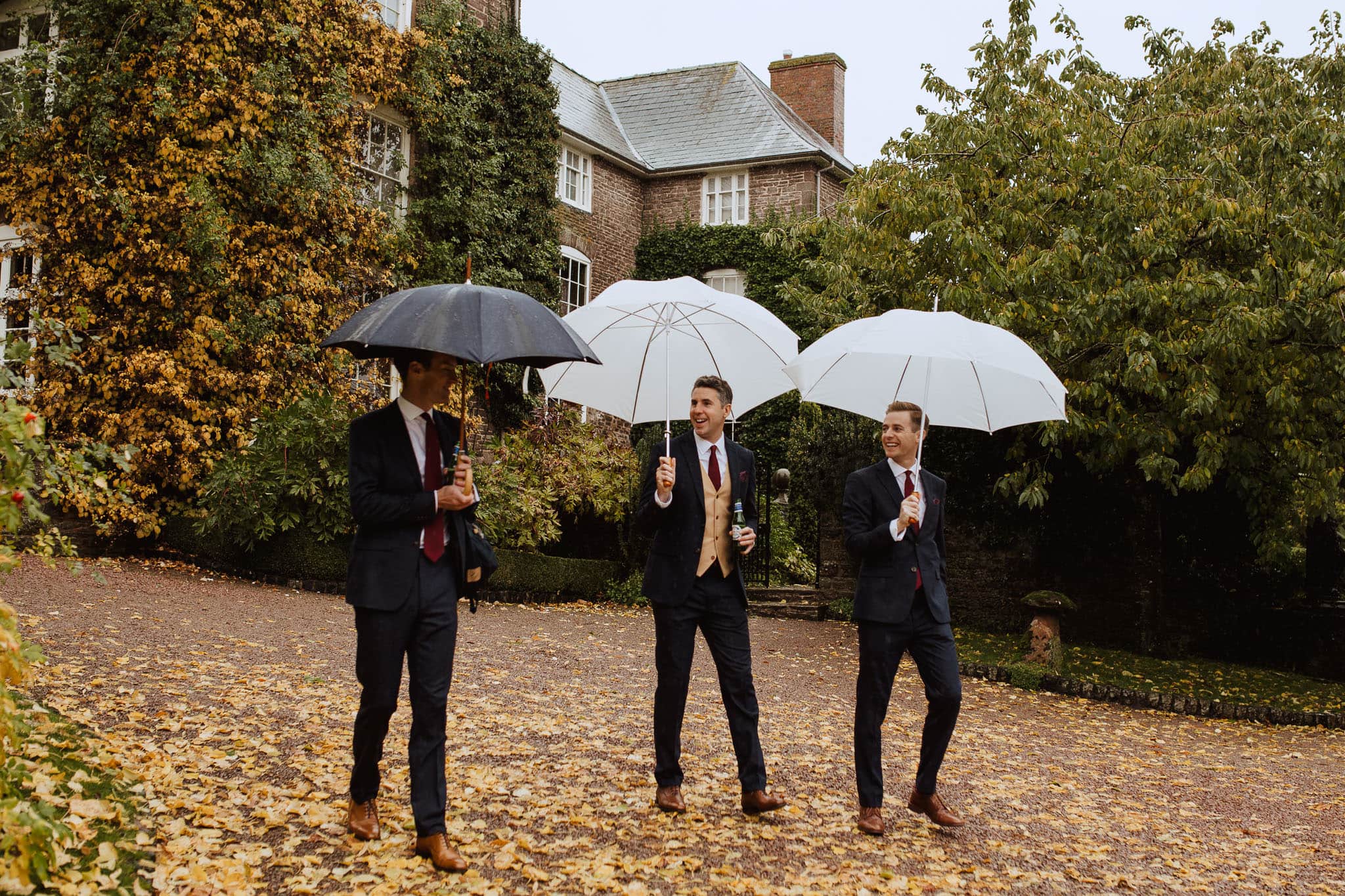 Dewsall Court Herefordshire wedding groomsmen with umbrellas