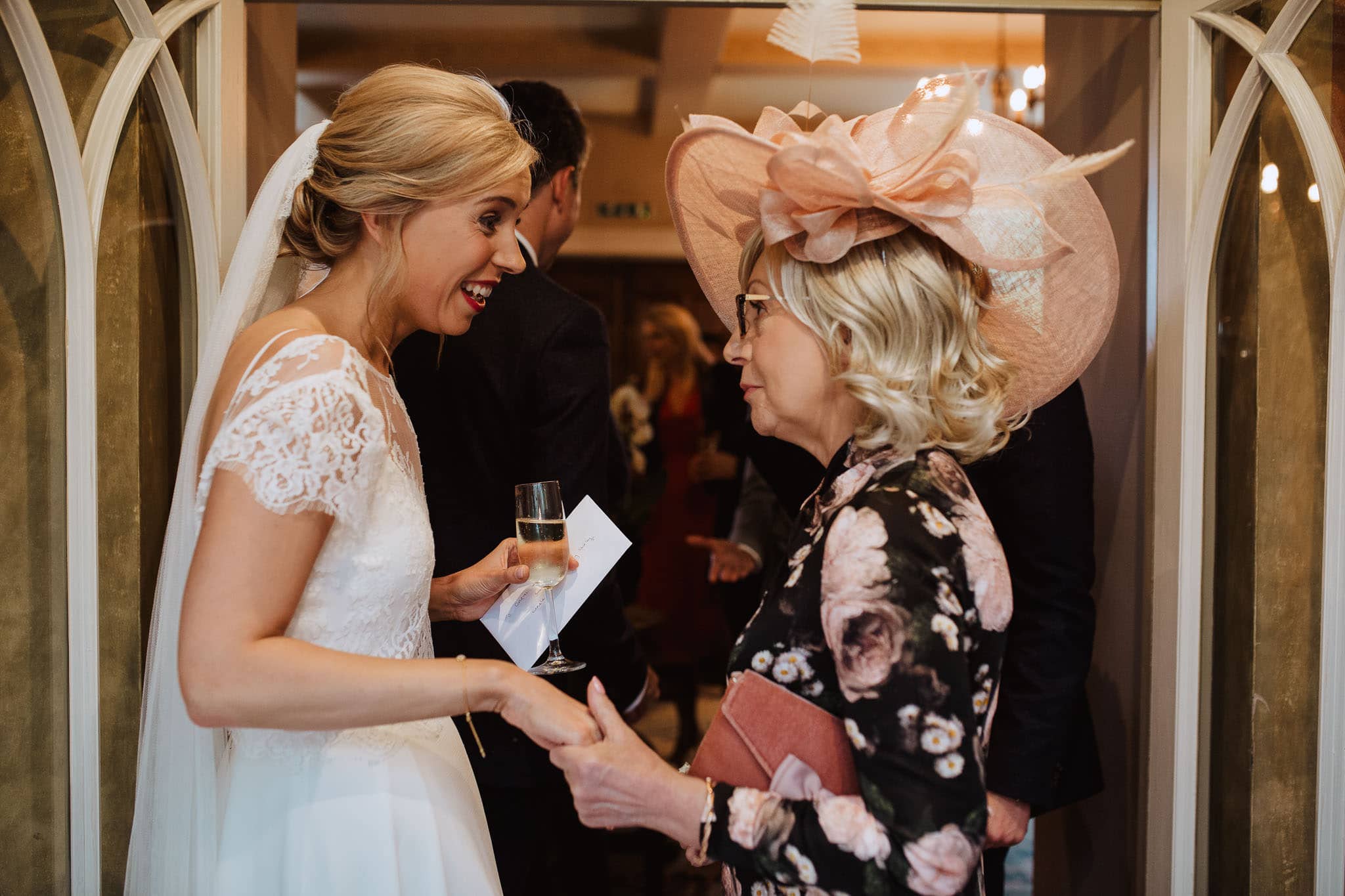 bride and mother of the groom holding hands