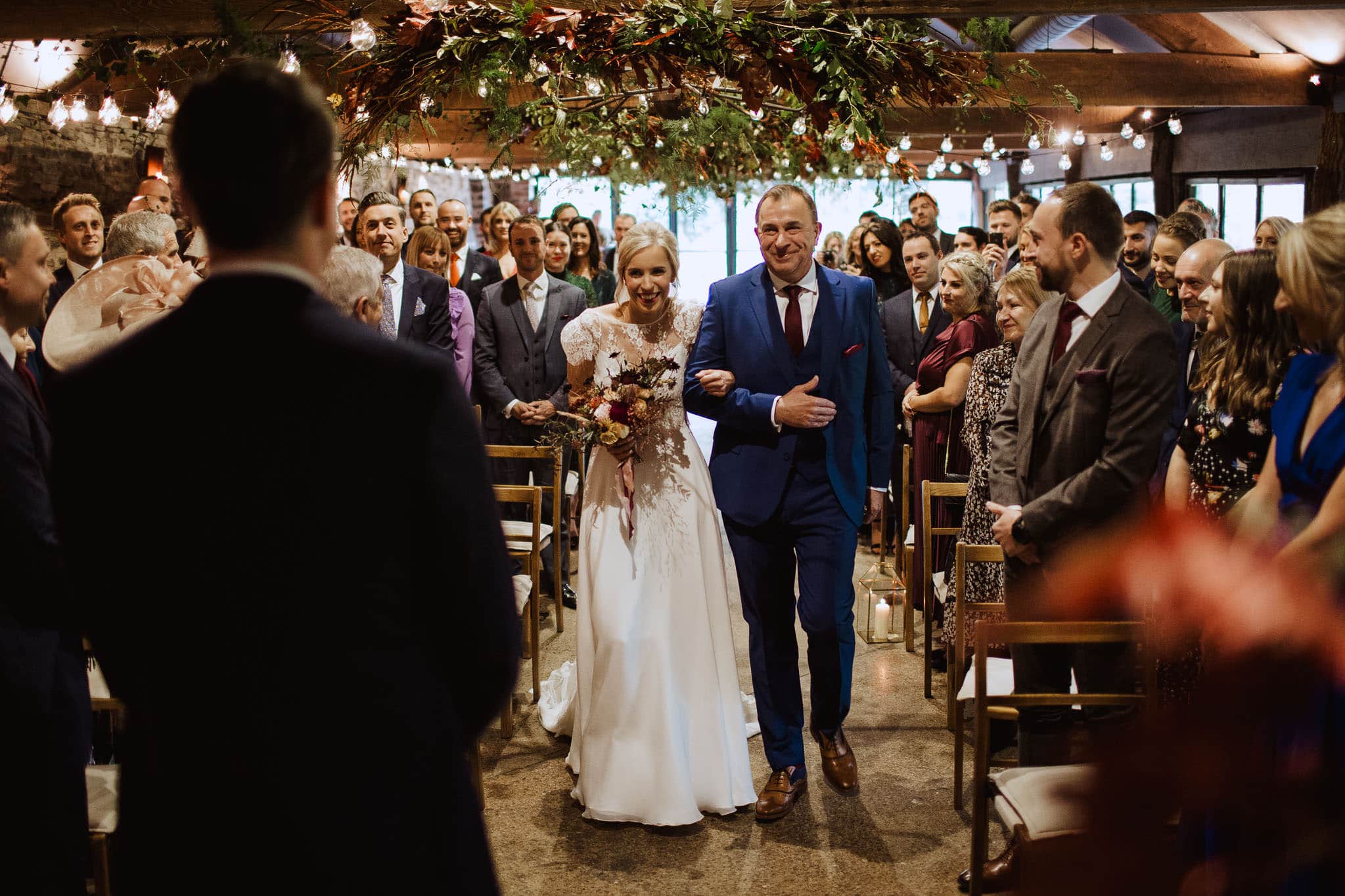 bride's entrance to ceremony in the barn at Dewsall Court