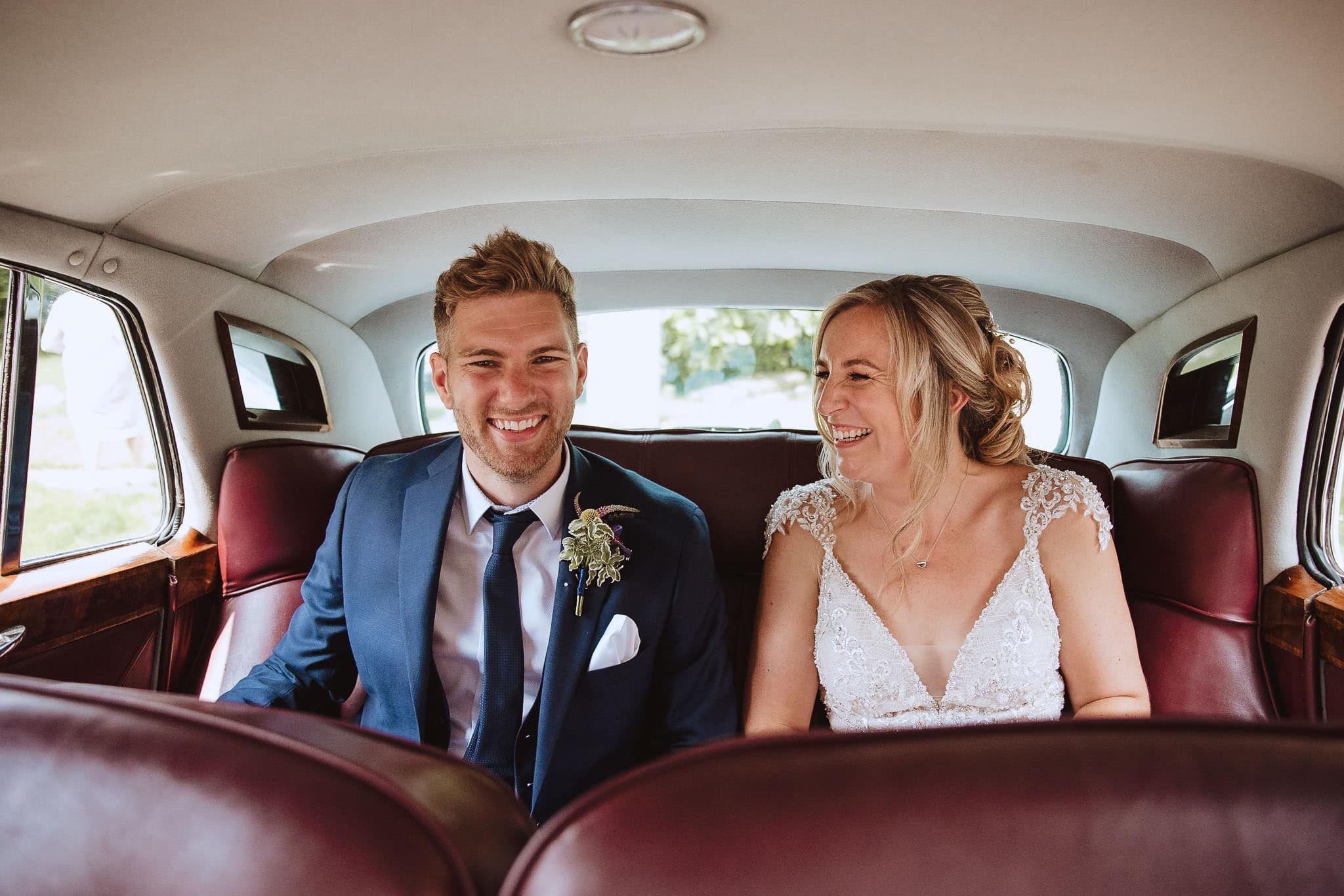 Red on Blonde photography shot of happy couple in vintage car