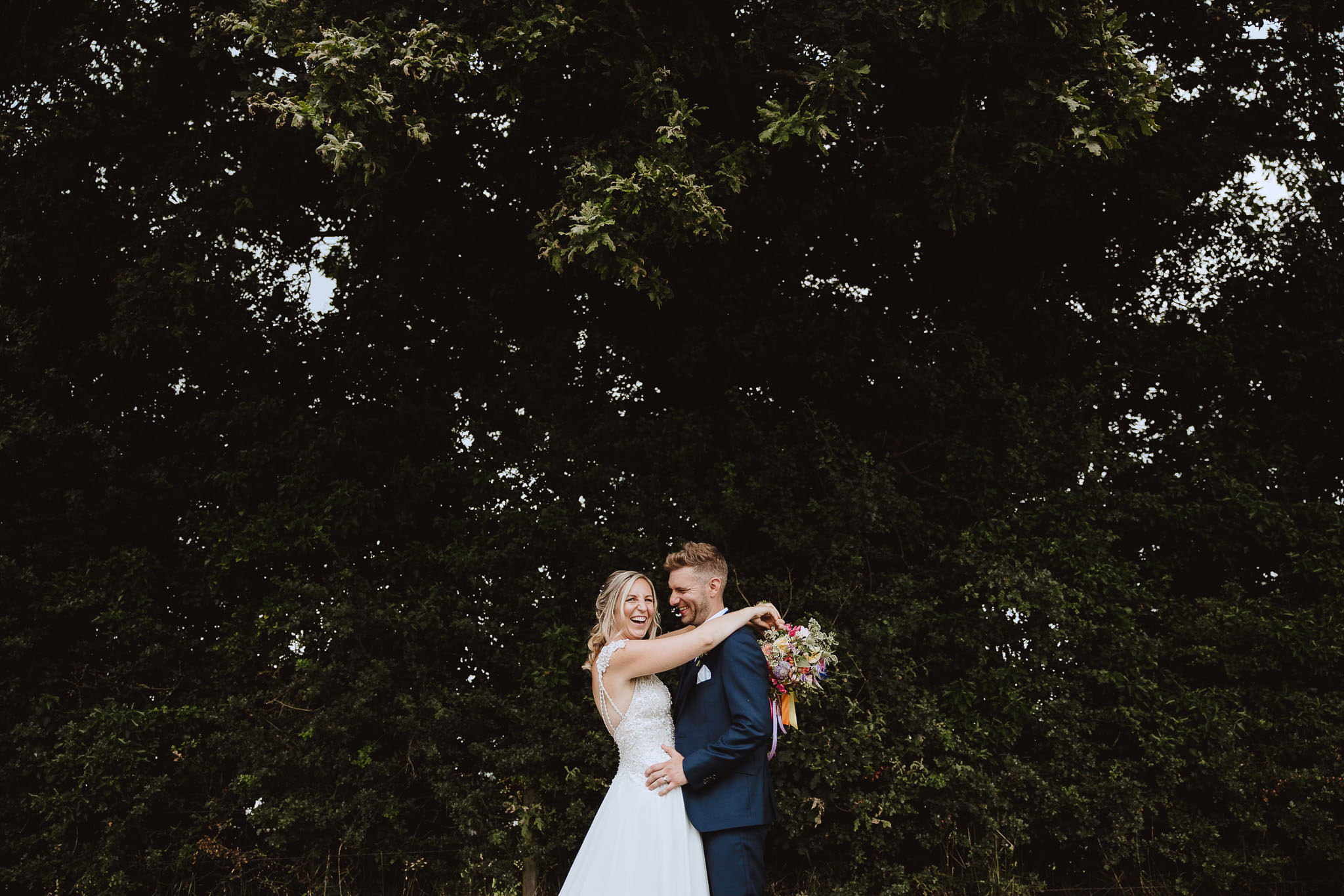 bride and groom surrounded by trees