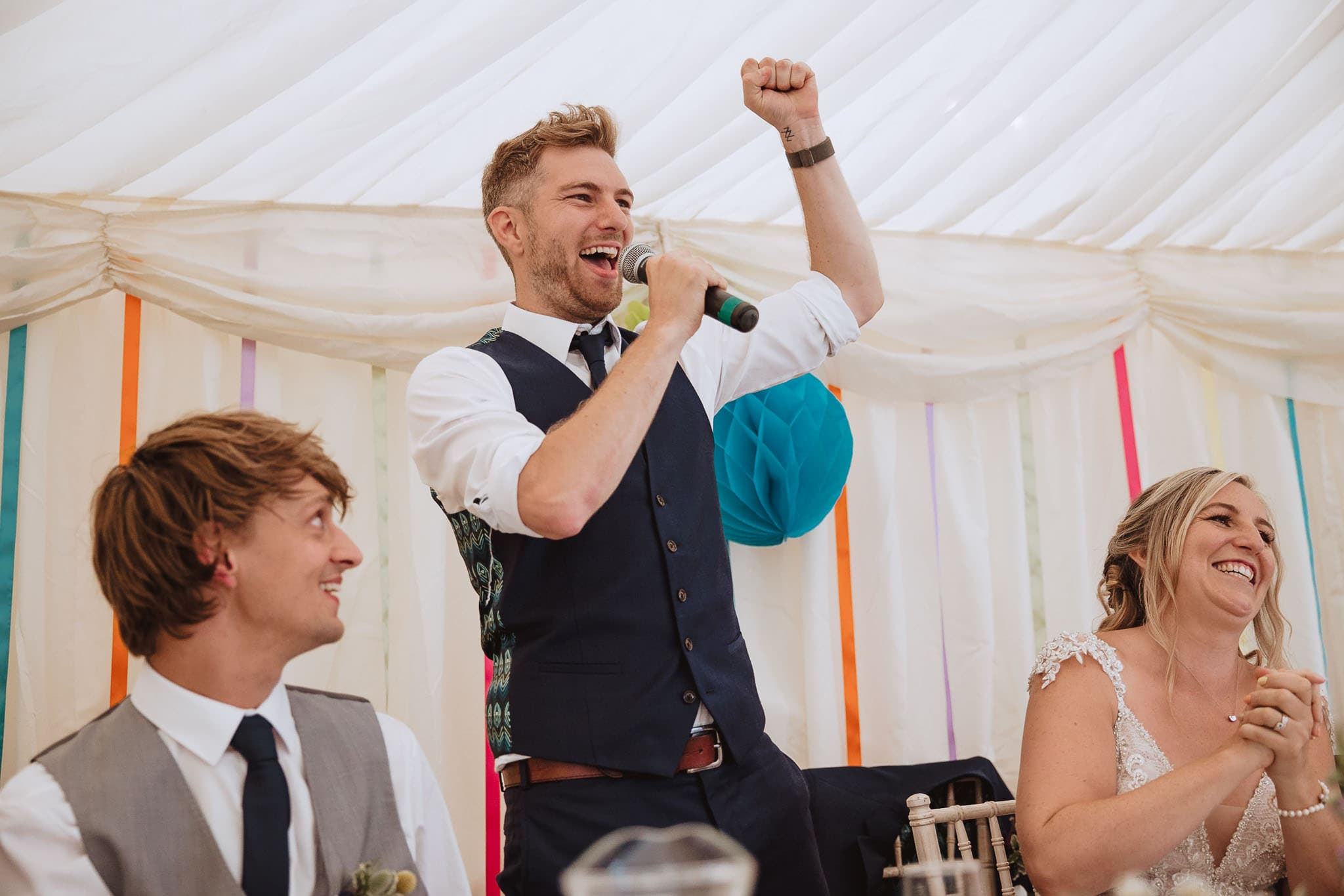groom cheering during speeches at marquee wedding