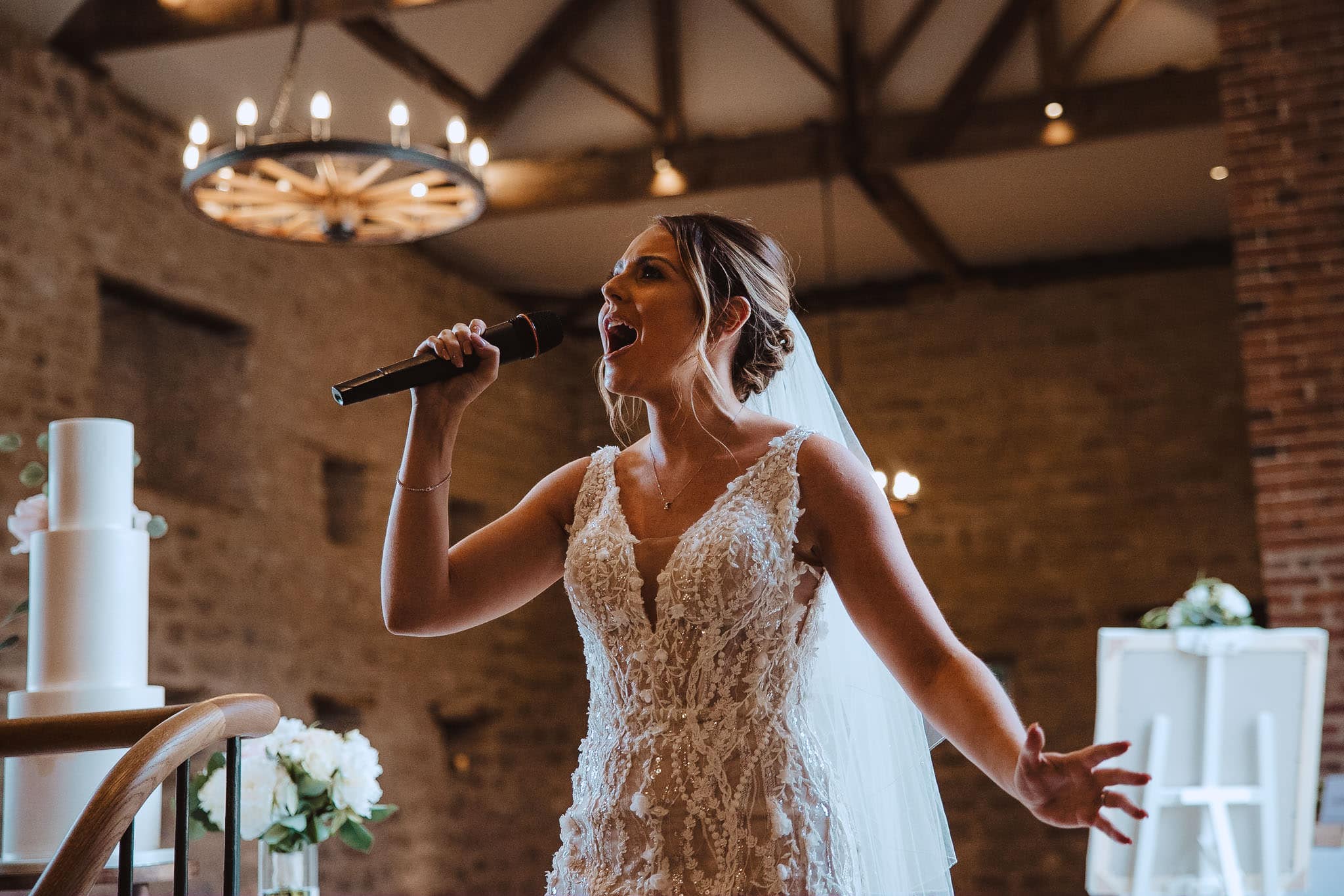 bride sings surprise Lady Gaga song for groom in barn at natural portraits by Red on Blonde Photography at Hooton Pagnell Hall wedding