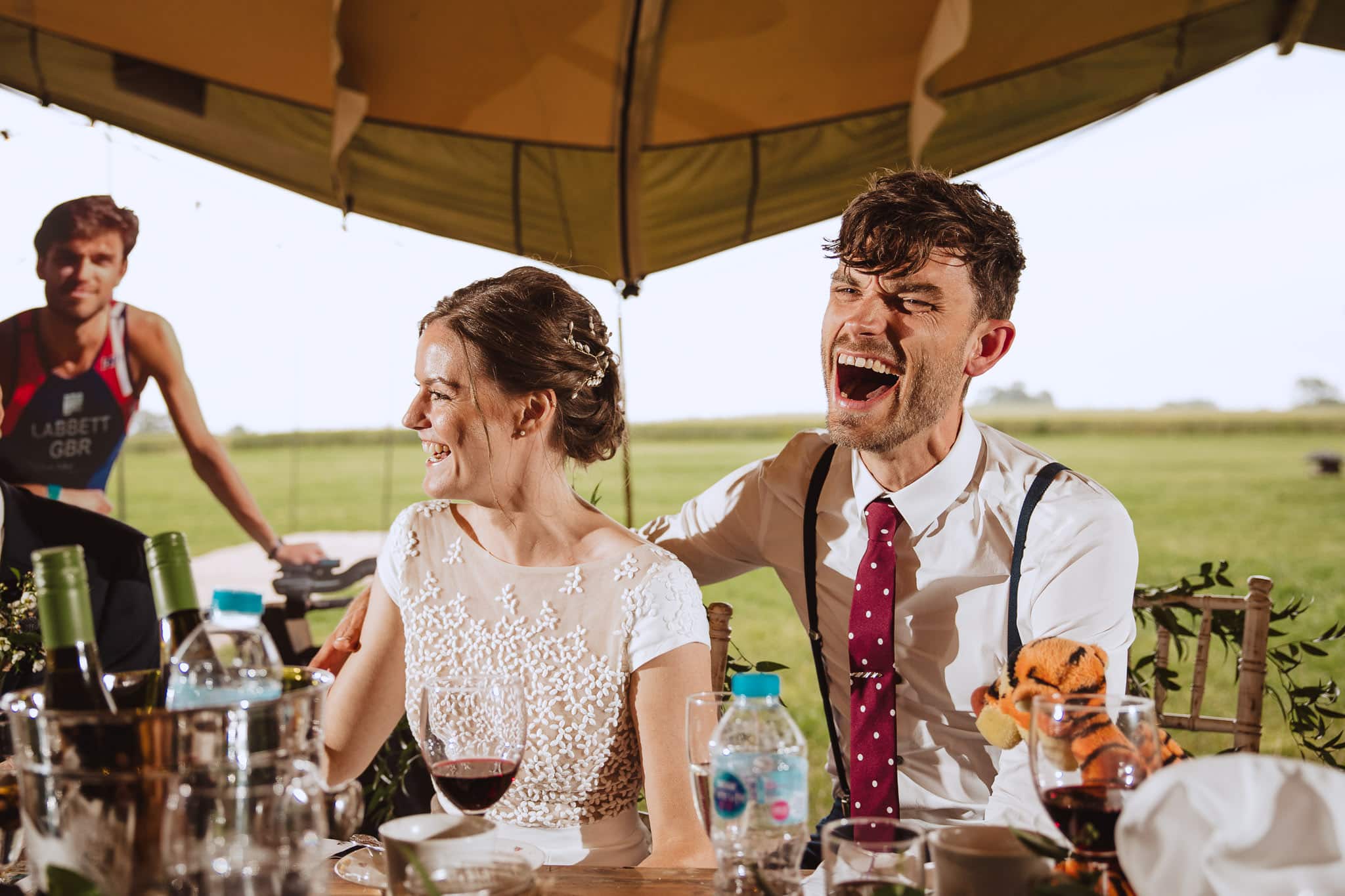 close up of bride and groom laughing hilariously at speeches