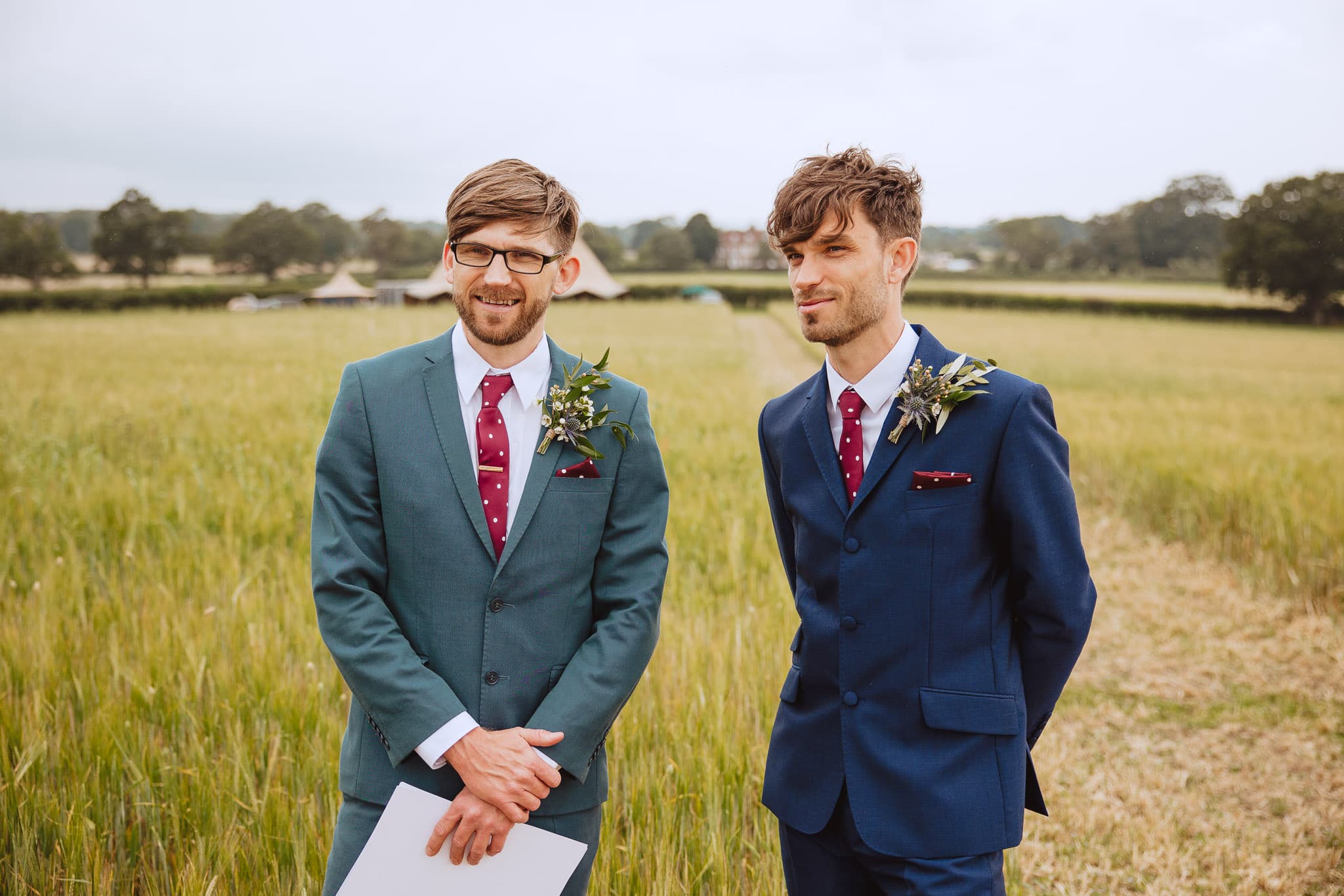 the groom and his brother waiting for the bride at their outdoor wedding ceremony