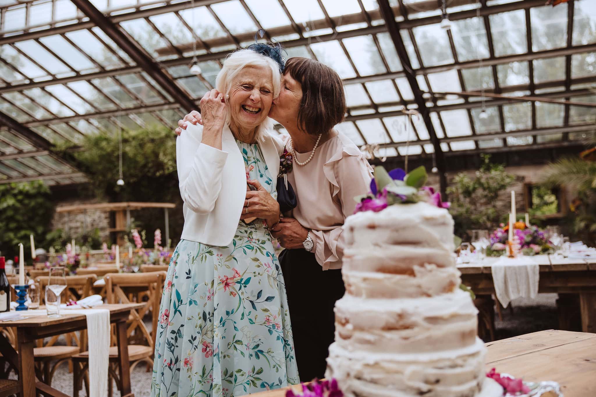 two wedding guests admiring the homemade wedding cake