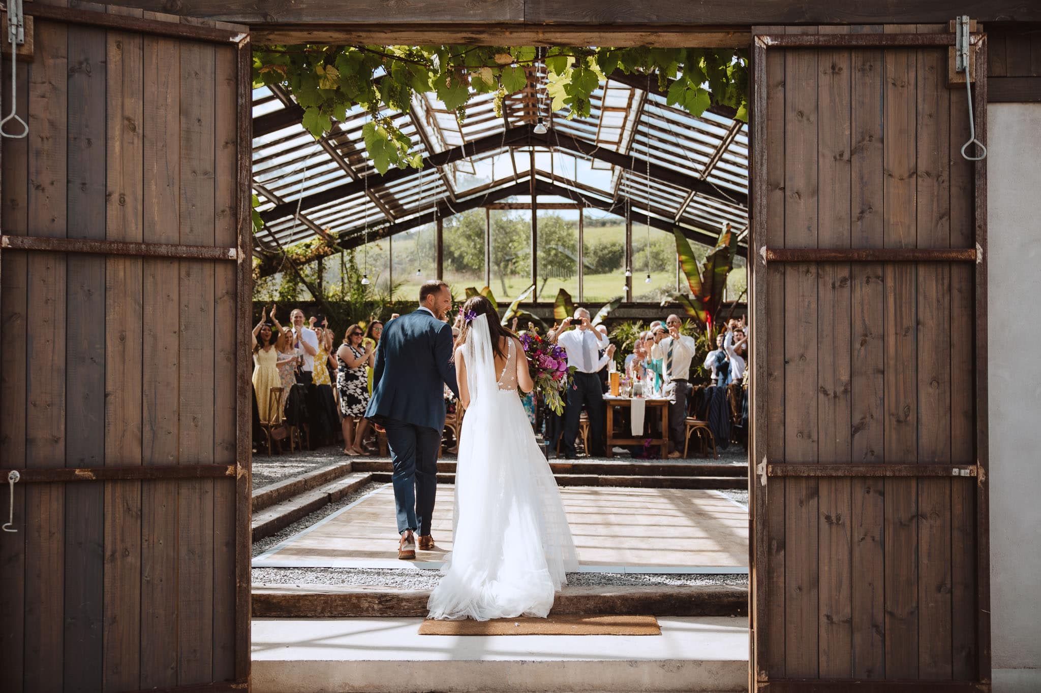 bride and groom entering the glasshouse at Anran exclusive wedding, Devon
