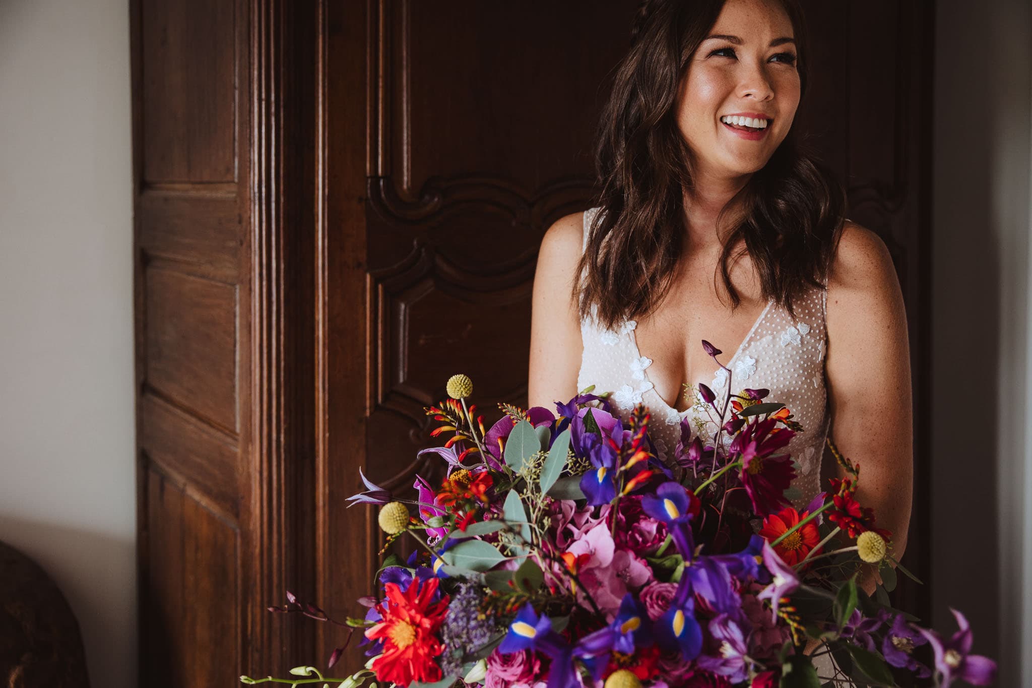 close up of bride with bold, bight bouquet