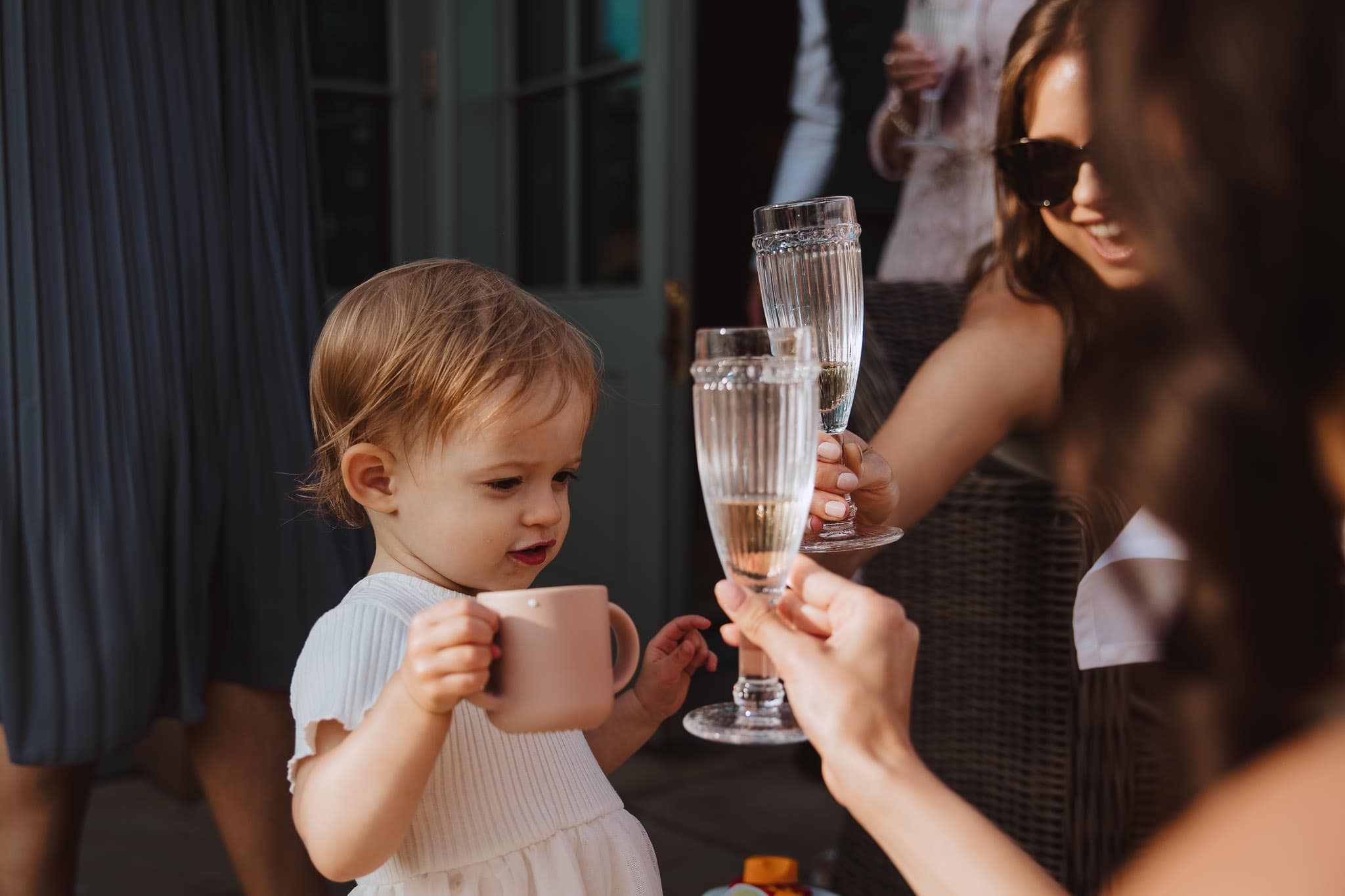 little girl cheers with the wedding guests