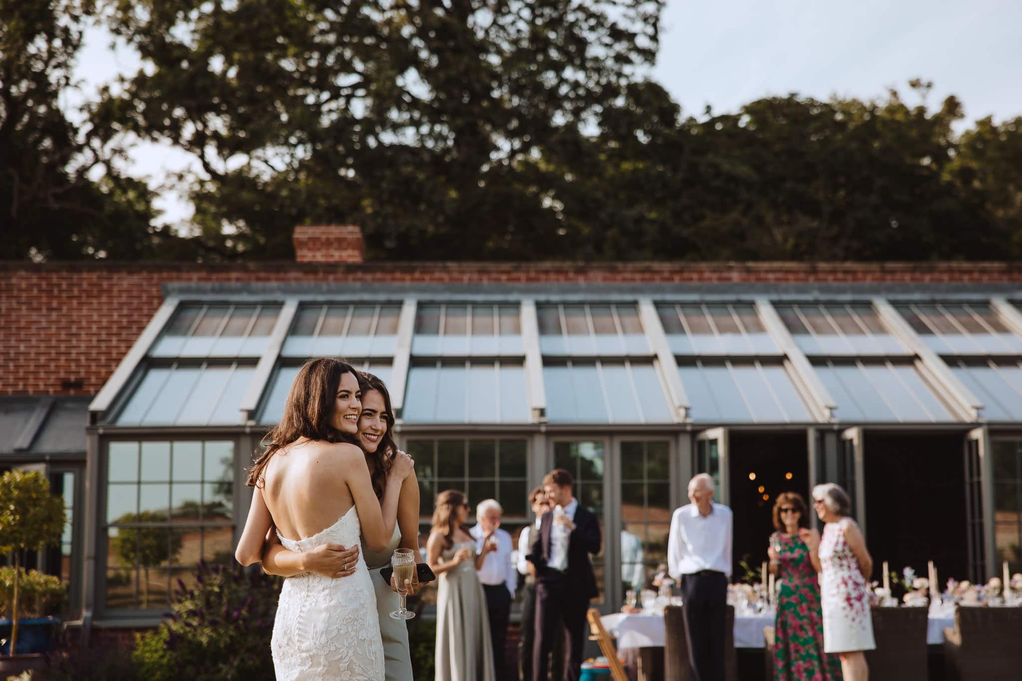 bride and bridesmaid hugging at Suffolk wedding