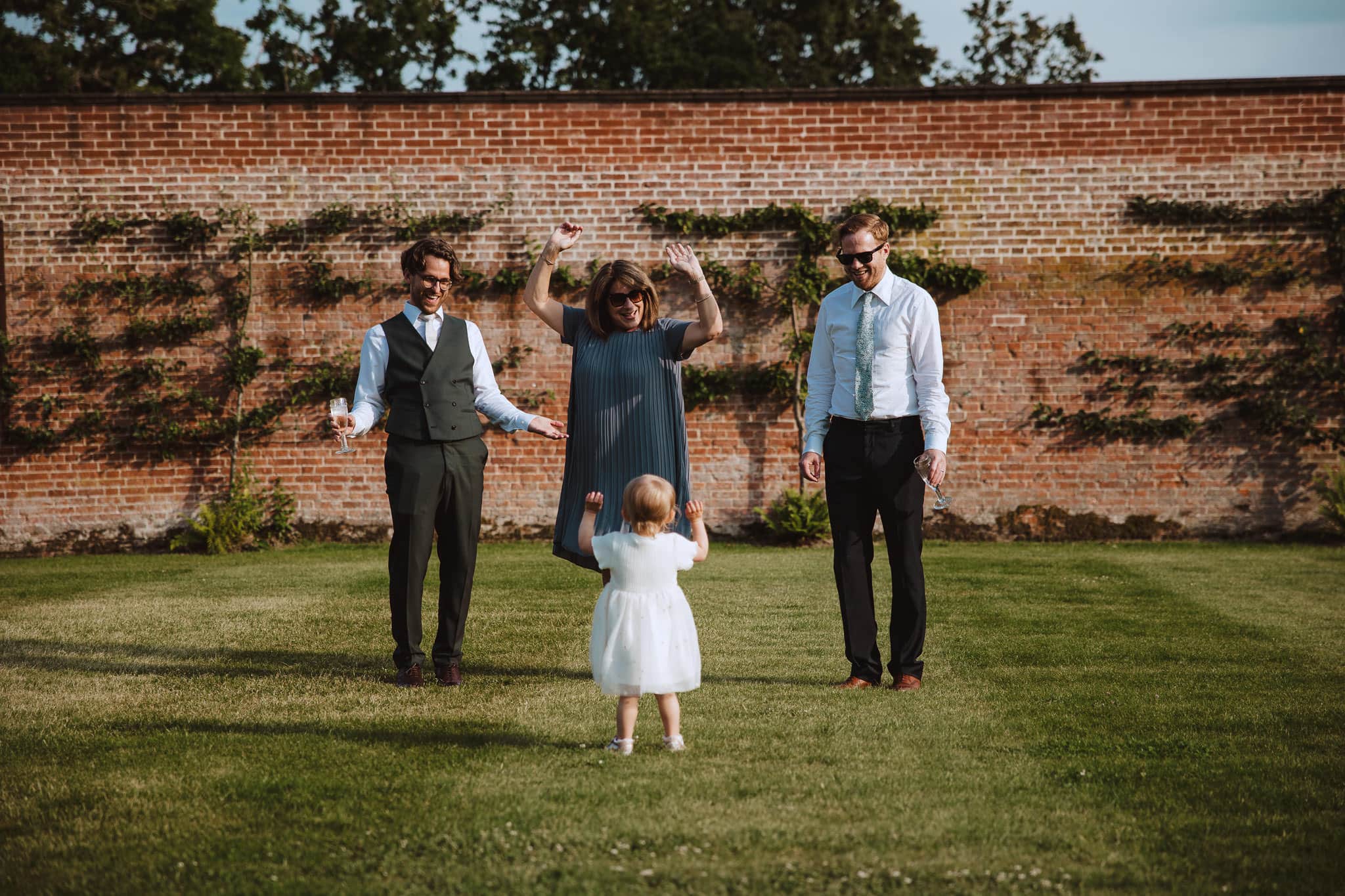 walled garden wedding guests having fun with flower girl