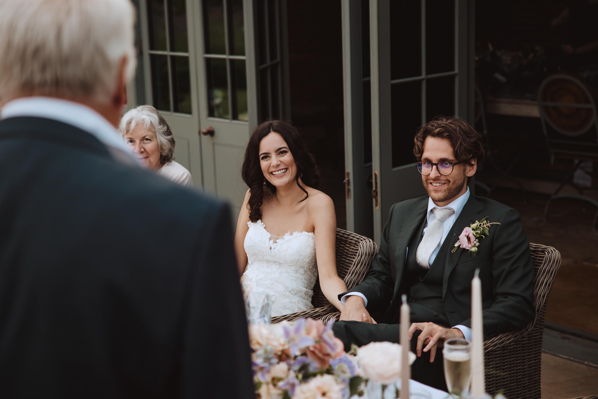 close up of bride and groom listening to Dad's wedding speech