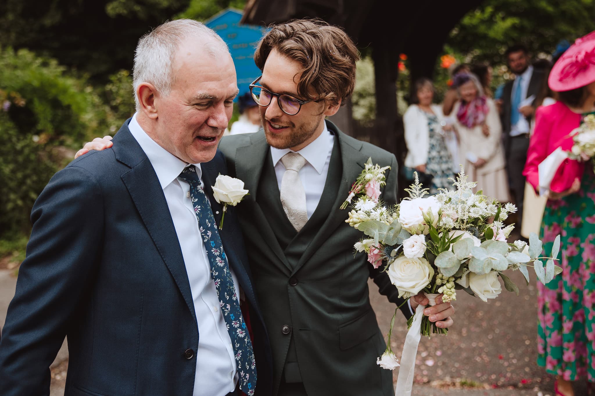 documentary wedding photographer photo of groom and his new father in law hugging