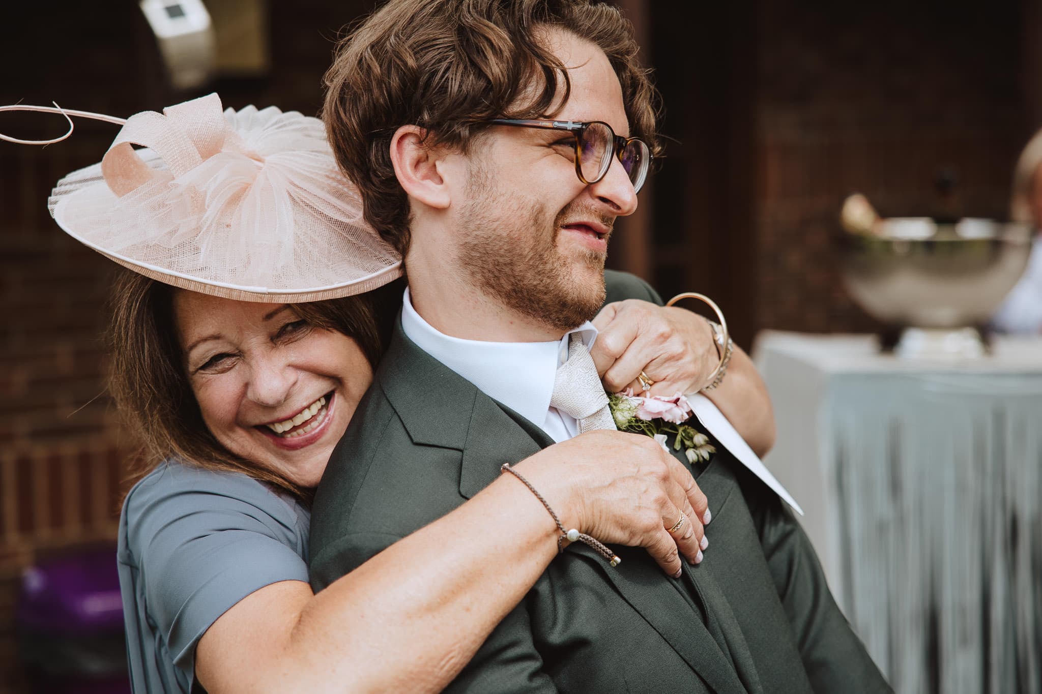 close up of wedding guest hugging groom