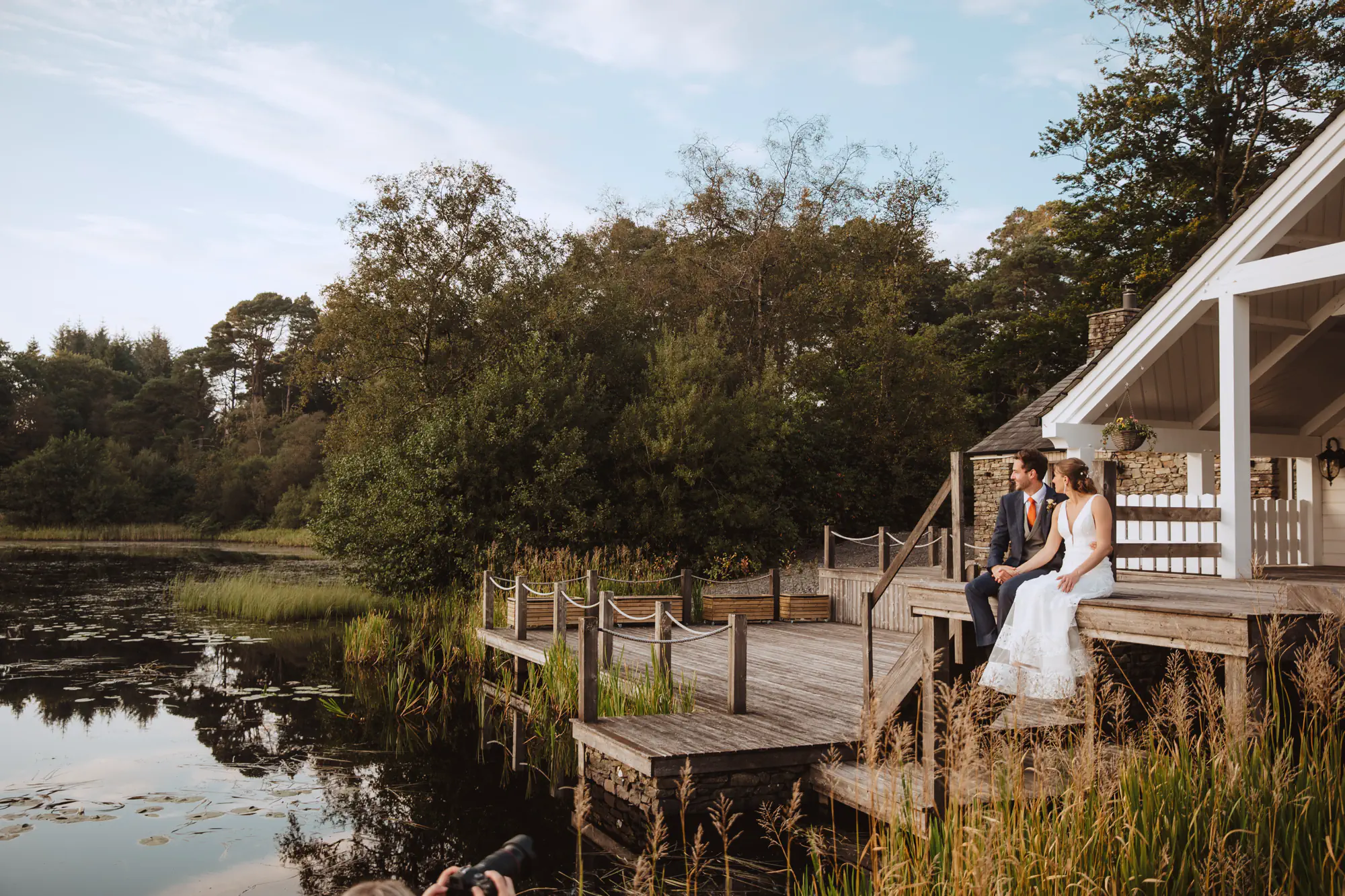 Couple sitting by lake at wedding venue - wedding videographer Derbyshire