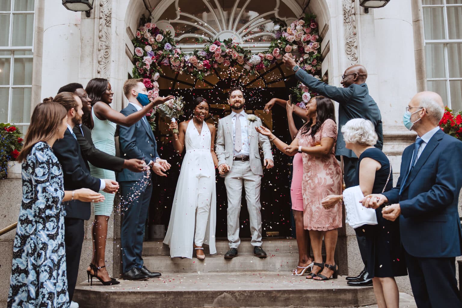 Bride and groom walking through confetti - natural wedding photography Derbyshire